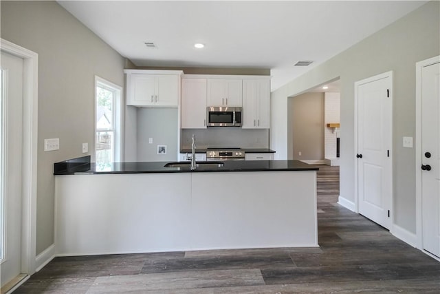 369 Lightness Dr, Auburn, AL 36832 - kitchen featuring appliances with stainless steel finishes, a sink, dark countertops, white cabinetry, and dark wood-type flooring