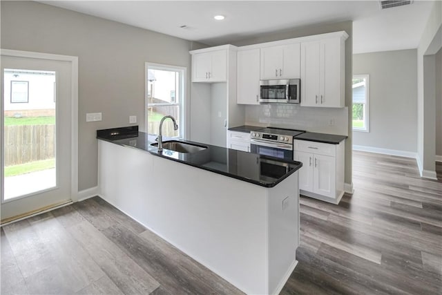 369 Lightness Dr, Auburn, AL 36832 - kitchen featuring a sink, stainless steel appliances, dark countertops, dark wood-type flooring, and a peninsula