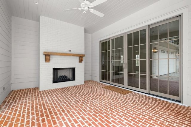 view of patio featuring a brick fireplace and ceiling fan