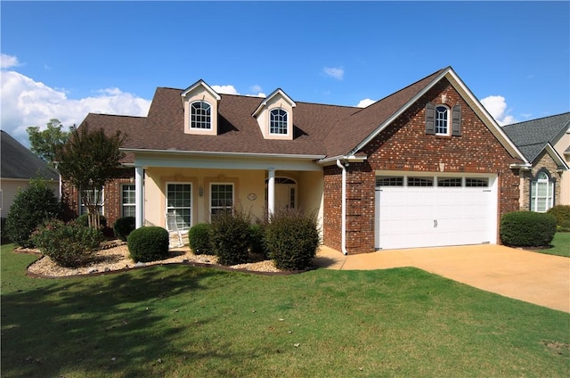 view of front of home with covered porch, a garage, and a front lawn