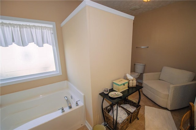 bathroom with a textured ceiling, toilet, and a tub