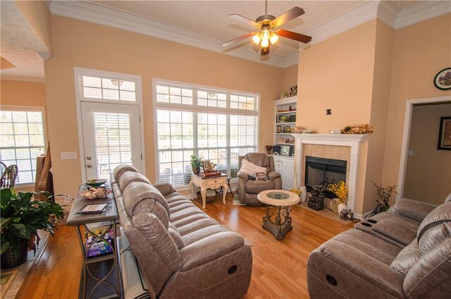 living room with a fireplace, light hardwood / wood-style floors, and ornamental molding