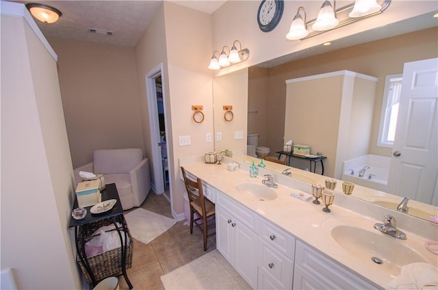 bathroom featuring a bathing tub, tile patterned flooring, a textured ceiling, toilet, and vanity