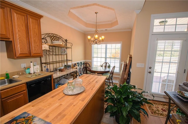 kitchen with dishwasher, wooden counters, crown molding, a tray ceiling, and decorative light fixtures