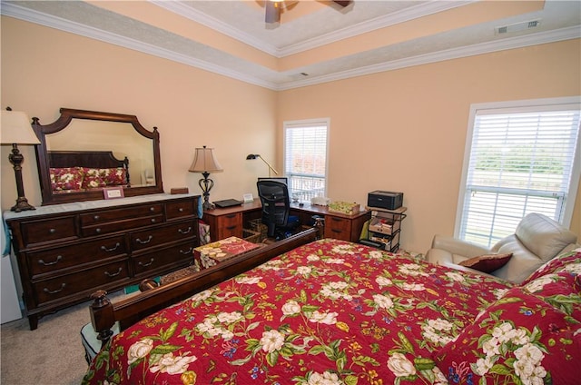 carpeted bedroom with a raised ceiling, ceiling fan, and crown molding