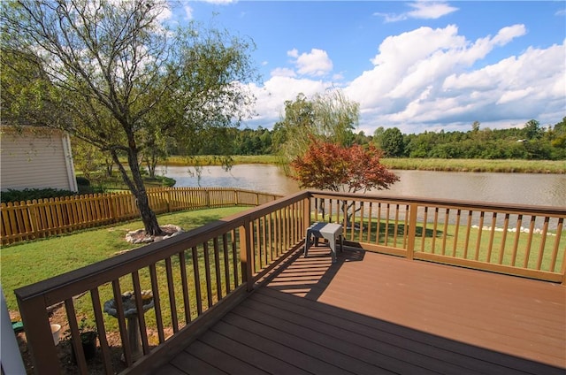 wooden deck with a lawn and a water view