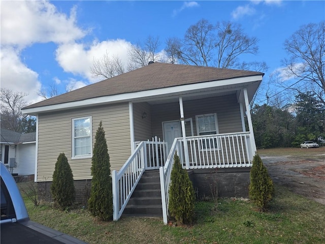 bungalow-style house with covered porch and roof with shingles