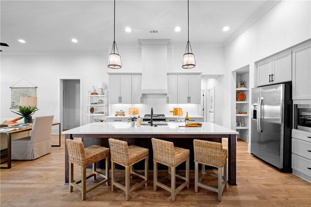 124 Merlin St, Opelika, AL 36801 - kitchen featuring appliances with stainless steel finishes, open shelves, crown molding, light countertops, and a breakfast bar area