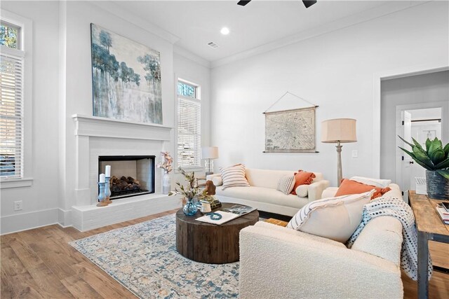 124 Merlin St, Opelika, AL 36801 - living area with crown molding, wood finished floors, a ceiling fan, a fireplace with raised hearth, and recessed lighting