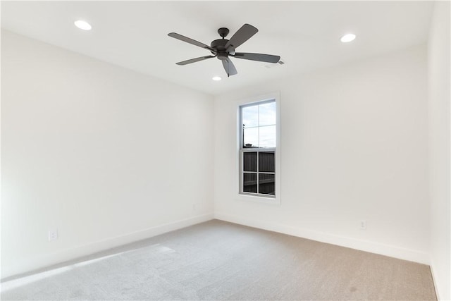 empty room featuring ceiling fan and light colored carpet