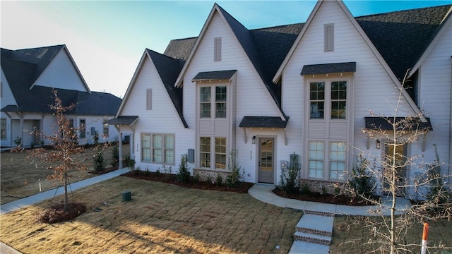 view of front of home with a front yard and central AC