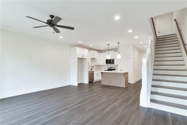 unfurnished living room featuring ceiling fan, sink, and dark wood-type flooring