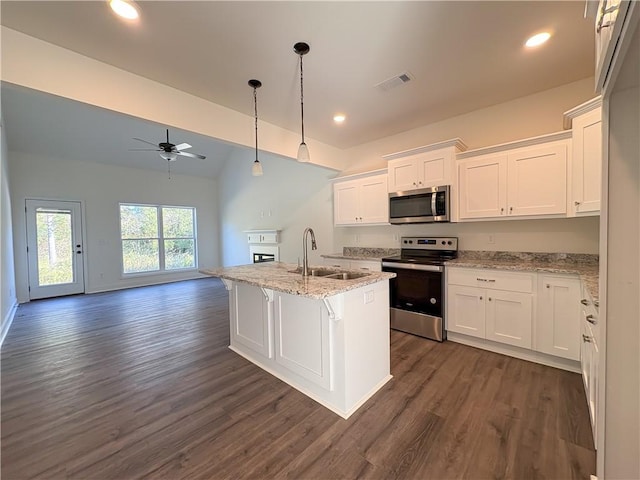 kitchen featuring light stone countertops, white cabinetry, sink, a kitchen island with sink, and appliances with stainless steel finishes