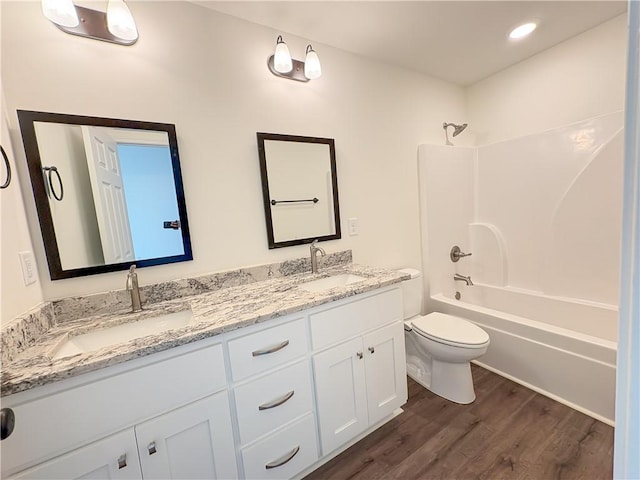 full bathroom featuring vanity, hardwood / wood-style flooring, toilet, and shower / washtub combination