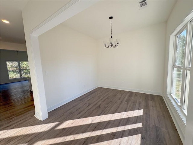 unfurnished dining area featuring dark hardwood / wood-style flooring and a notable chandelier