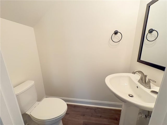 bathroom featuring toilet, wood-type flooring, sink, and vaulted ceiling