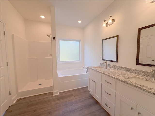 bathroom featuring plus walk in shower, wood-type flooring, and vanity