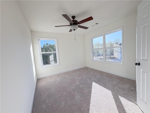 empty room featuring ceiling fan and light colored carpet