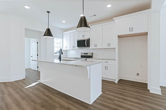 1021 Crossing Ct E, Valley, AL 36854 - kitchen with stainless steel appliances, dark wood-type flooring, decorative backsplash, white cabinets, and a center island with sink