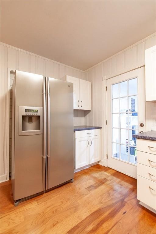 kitchen featuring stainless steel refrigerator with ice dispenser, light wood-type flooring, and white cabinetry