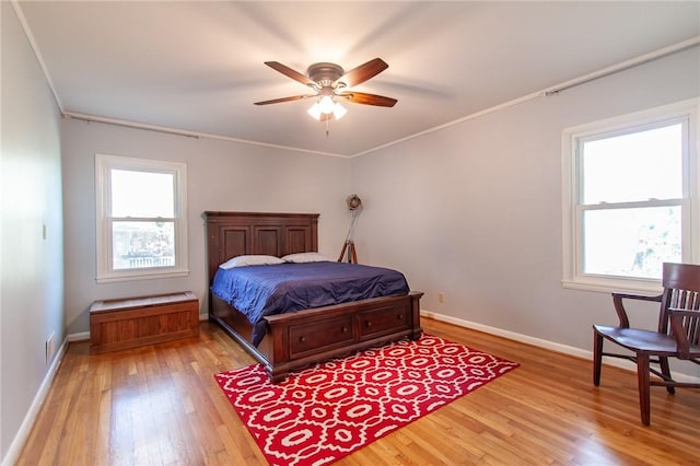 bedroom featuring ceiling fan, ornamental molding, and light wood-type flooring