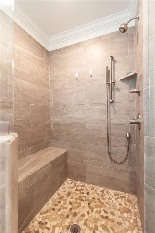 bathroom featuring a tile shower and ornamental molding