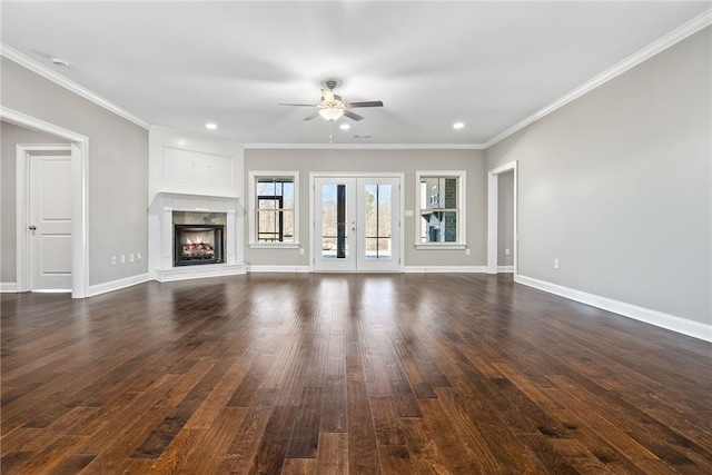 unfurnished living room with dark wood-style floors, french doors, a fireplace, ornamental molding, and baseboards