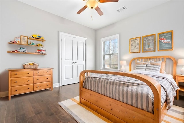 bedroom featuring a ceiling fan, visible vents, dark wood finished floors, and baseboards