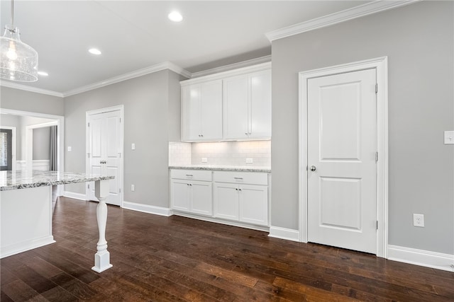 kitchen featuring light stone counters, dark wood-style flooring, white cabinets, backsplash, and crown molding