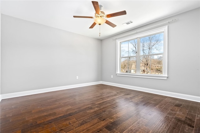 unfurnished room with baseboards, visible vents, ceiling fan, and dark wood-type flooring