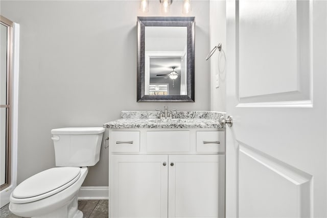 bathroom featuring baseboards, vanity, and toilet