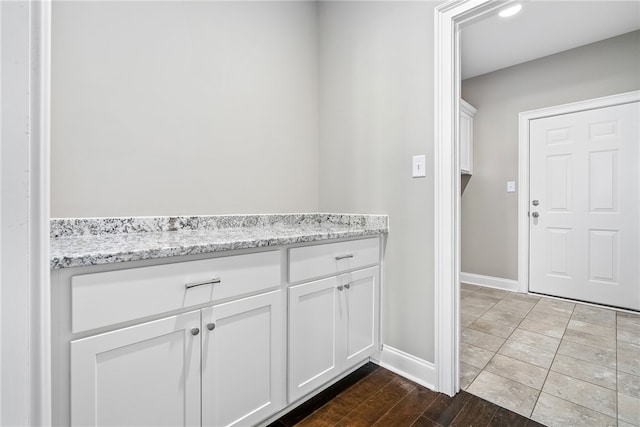 interior space with vanity, baseboards, and wood finished floors