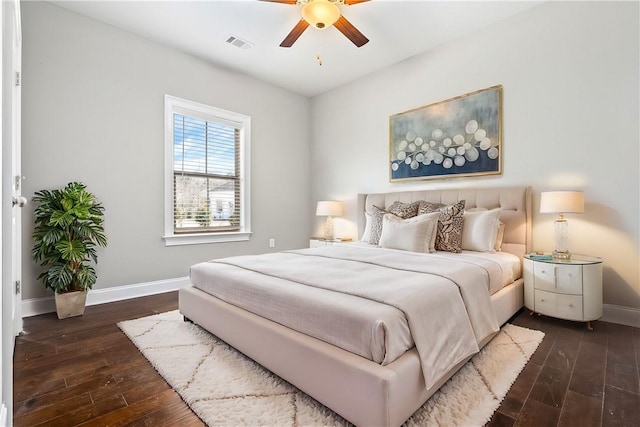 bedroom featuring baseboards, visible vents, dark wood finished floors, and a ceiling fan