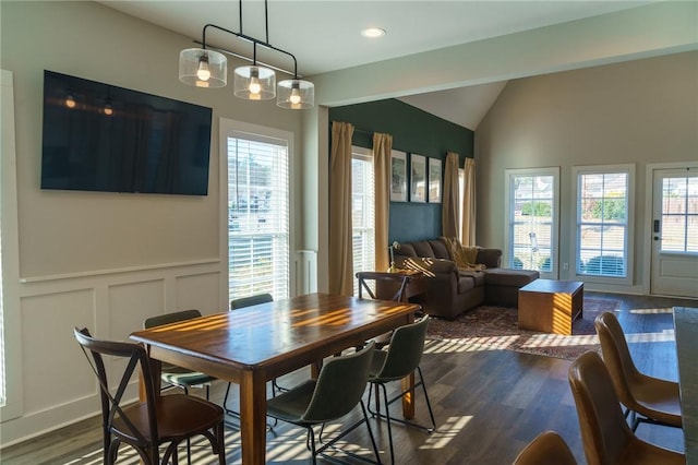 dining space with a wealth of natural light, dark wood-style flooring, wainscoting, and vaulted ceiling