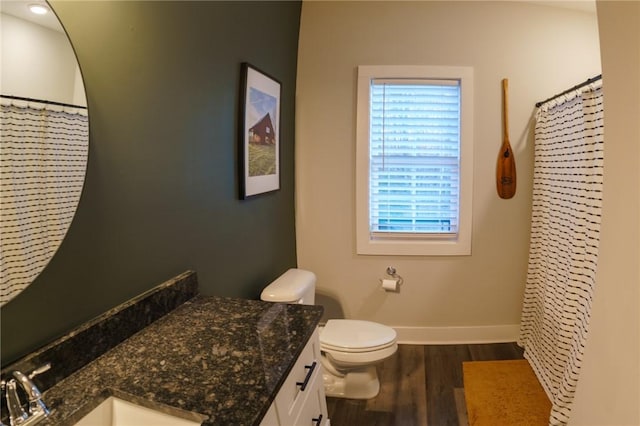 bathroom featuring vanity, a shower with shower curtain, wood finished floors, baseboards, and toilet