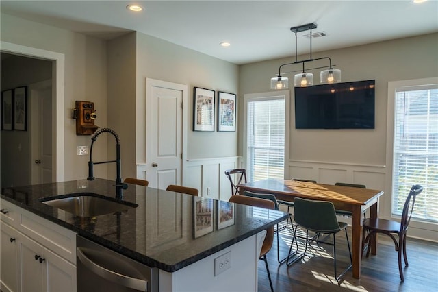 kitchen featuring a wealth of natural light, visible vents, white cabinets, and a sink