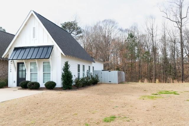 view of home's exterior with board and batten siding, a standing seam roof, metal roof, and a shingled roof