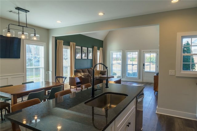 kitchen featuring dark stone countertops, visible vents, a wealth of natural light, and a sink