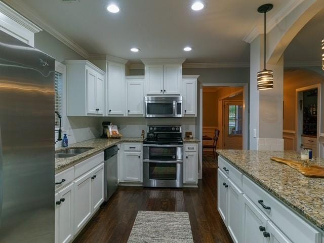 1201 Live Oak Cir, Opelika, AL 36801 - kitchen with stainless steel appliances, a sink, arched walkways, dark wood finished floors, and ornamental molding