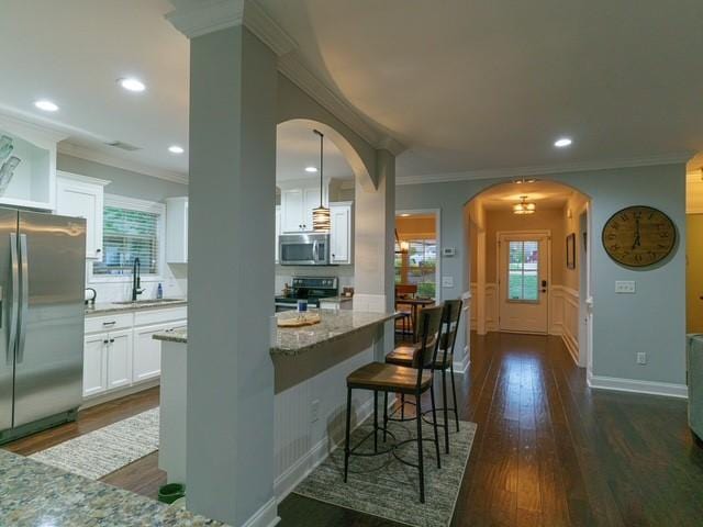 1201 Live Oak Cir, Opelika, AL 36801 - kitchen with appliances with stainless steel finishes, arched walkways, a sink, ornamental molding, and white cabinetry