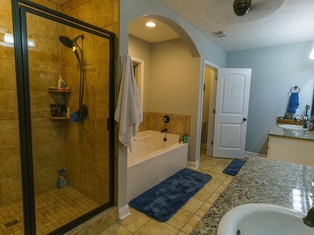 1201 Live Oak Cir, Opelika, AL 36801 - full bathroom featuring double vanity, tile patterned flooring, a bath, and a shower stall