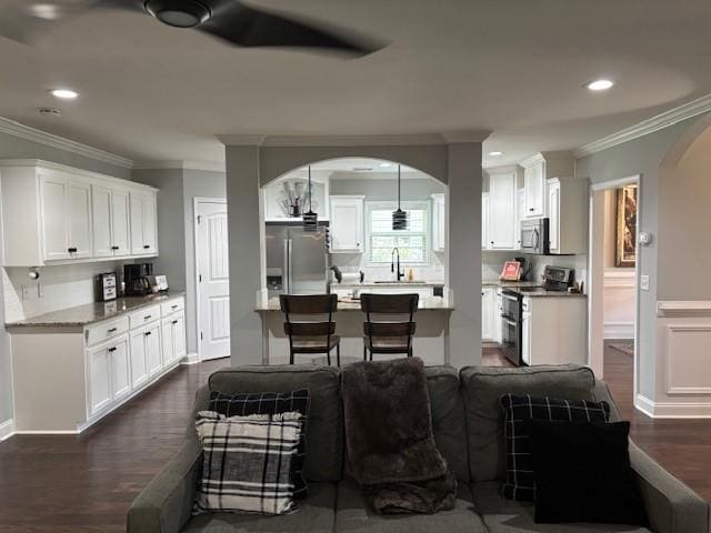 1201 Live Oak Cir, Opelika, AL 36801 - kitchen featuring appliances with stainless steel finishes, arched walkways, ornamental molding, dark wood finished floors, and white cabinetry