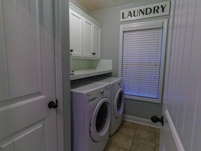 1201 Live Oak Cir, Opelika, AL 36801 - laundry room featuring cabinet space, washing machine and dryer, light tile patterned floors, and baseboards