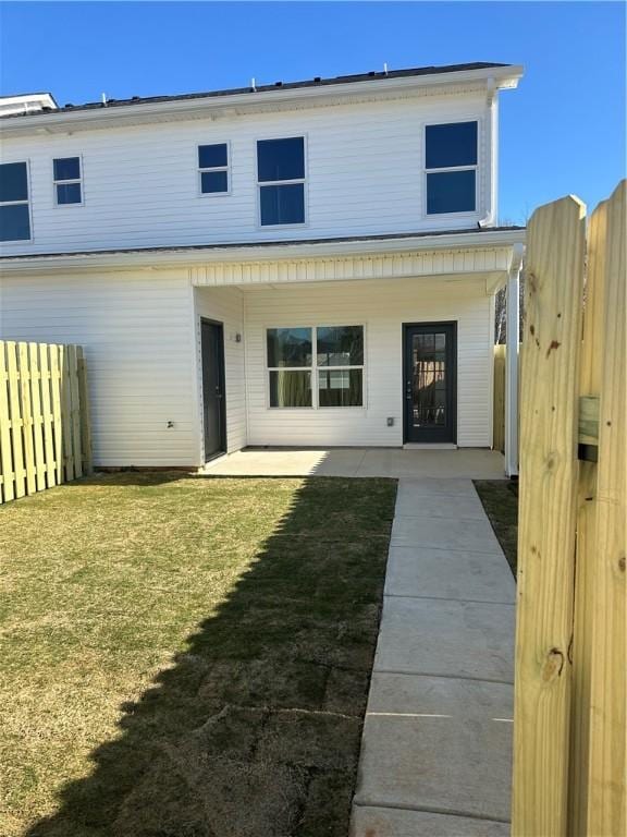 rear view of property featuring a yard and a patio