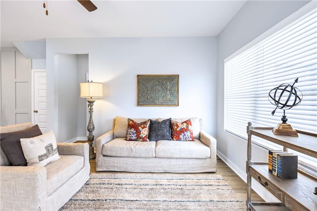 living room featuring a wealth of natural light, ceiling fan, and wood-type flooring