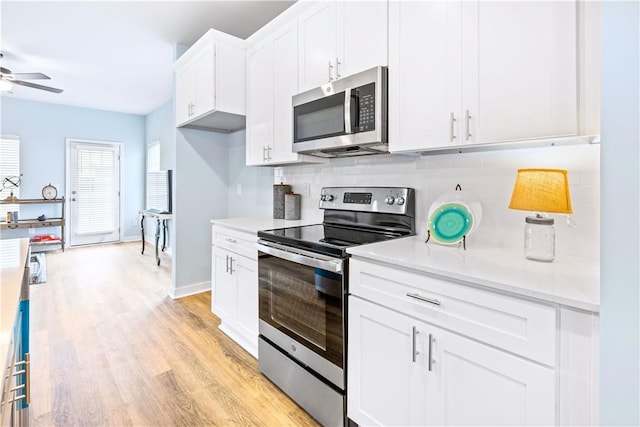 kitchen with ceiling fan, stainless steel appliances, tasteful backsplash, light hardwood / wood-style floors, and white cabinets