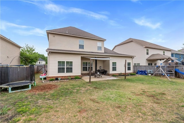 rear view of house with a trampoline, a patio area, a fenced backyard, a playground, and a yard