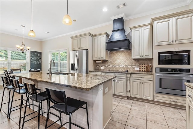 kitchen with decorative backsplash, appliances with stainless steel finishes, a sink, custom exhaust hood, and an inviting chandelier