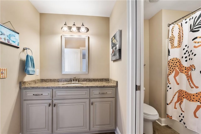 bathroom with vanity, baseboards, a shower with curtain, and toilet