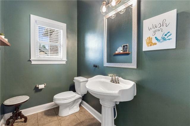 bathroom featuring toilet, tile patterned floors, and baseboards